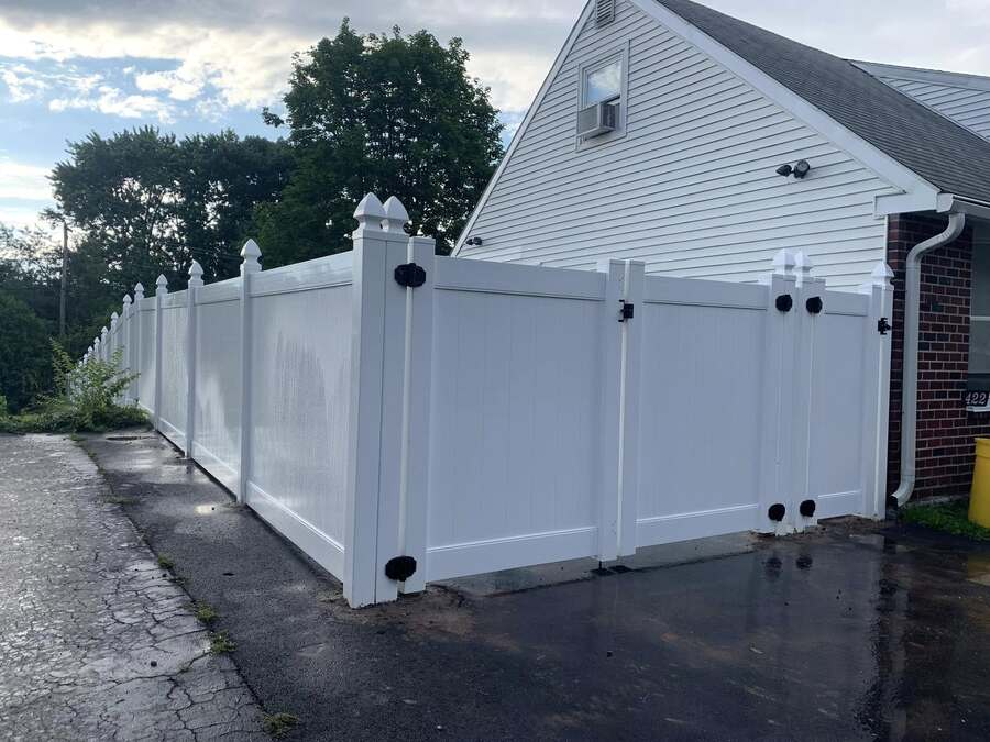 White vinyl fence enclosing a landscaped backyard