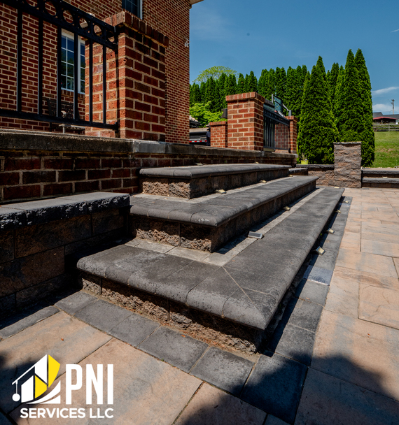Paver steps with brick wall railing. Entrance with paver steps and metal railing atop brick wall.
