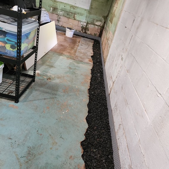 Professional applying waterproof coating to exterior residential wall